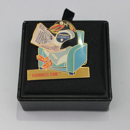 Guinness-themed enamel pin in a black box on a gray background