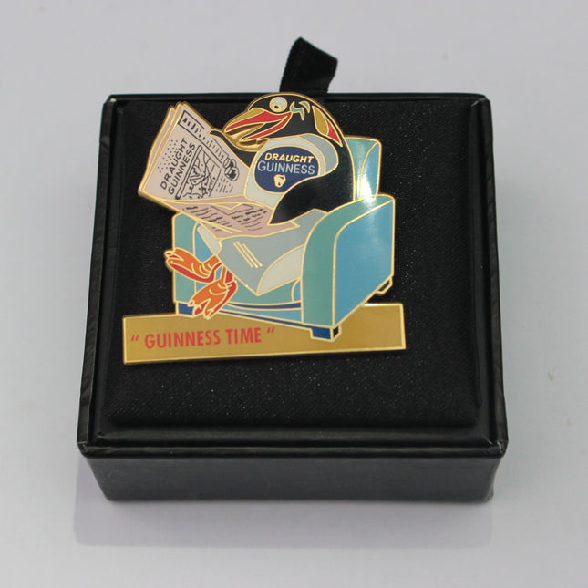 Guinness-themed enamel pin in a black box on a gray background