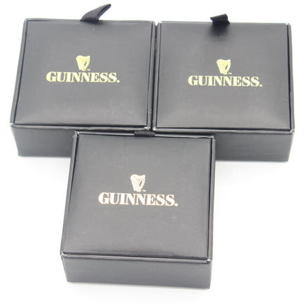 Three black Guinness badge boxes arranged on a white background, with the gold Guinness logo and harp emblem visible on the top of each box.