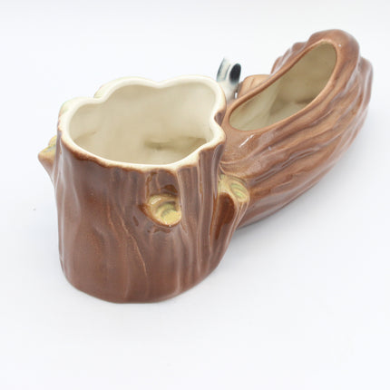 A ceramic planter shaped like a tree stump and branch, with a glossy brown finish and a small silver hanging loop, shown on a plain white background.