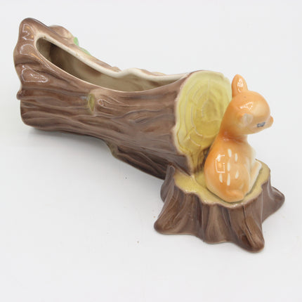 A ceramic tree stump planter with a small orange-brown squirrel figurine sitting on the stump, photographed on a plain white background.