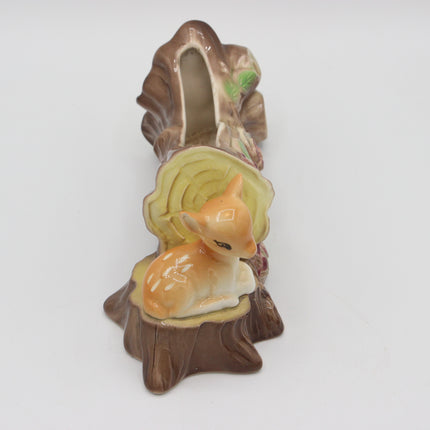 A ceramic woodland-themed dish or holder shaped like a tree stump with a small deer figurine nestled inside, photographed on a plain white background.