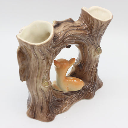 A ceramic double cup holder designed to look like a tree stump with a small glazed deer figurine inside, set against a plain white background.