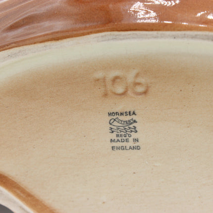 Close-up of the inside base of a ceramic dish or bowl, showing the embossed number 106, a Hornsea logo, and 'Made in England' text.