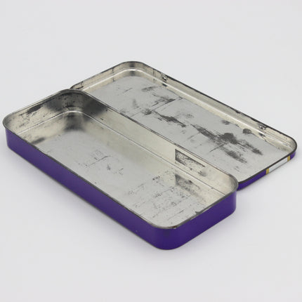 A rectangular metal tin box with a purple outer edge and a silver-colored interior, shown open on a plain light gray background.