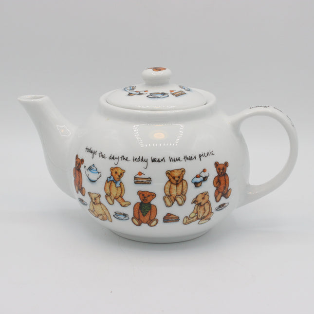 A white ceramic teapot decorated with illustrations of teddy bears, tea cups, cakes, and a handwritten quote on a light gray background.