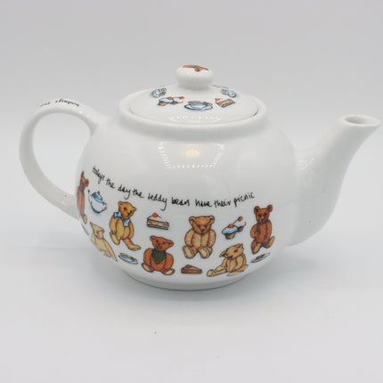 A white ceramic teapot decorated with colorful teddy bears, cupcakes, and a handwritten quote, shown on a light gray background.