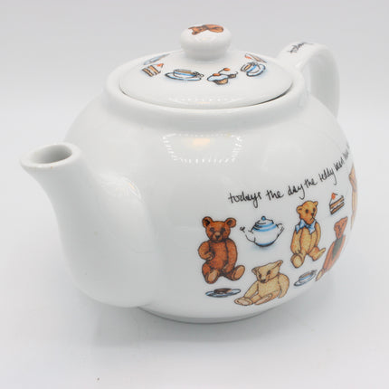 A white ceramic teapot decorated with teddy bear illustrations and small tea-time motifs, shown on a plain light gray background.