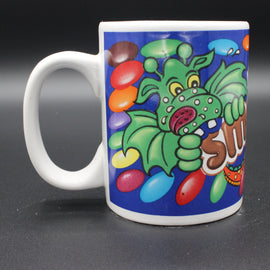 Colorful mug with a cartoon dragon design on a dark background