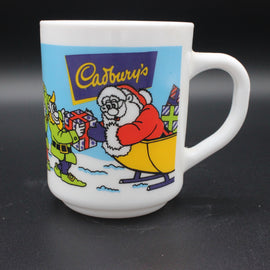 White mug with Cadbury's Christmas-themed design featuring Santa Claus and a reindeer on a black background.
