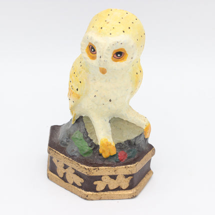 Cream and yellow vintage owl doorstop on a dark base with gold-coloured leaf motifs