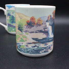 Mug with a scenic design of trees and water on a dark background