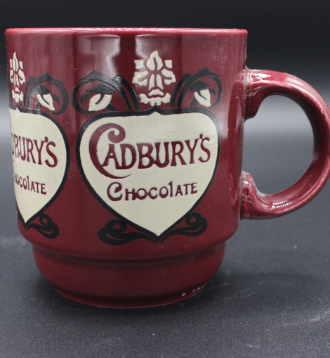 Red mug with Cadbury's Chocolate logo on a dark background