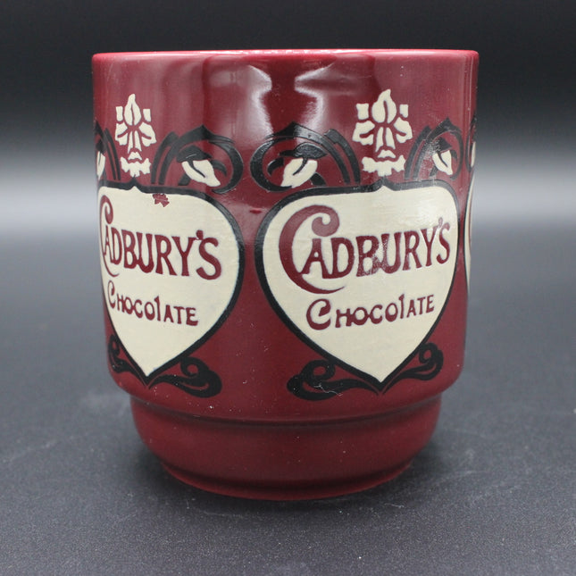 Red mug with Cadbury's Chocolate branding on a dark background