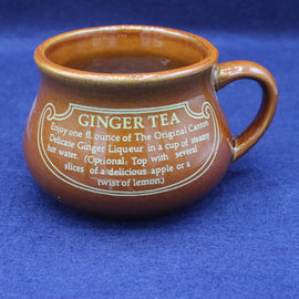 Brown ceramic mug with ginger tea instructions on a blue background