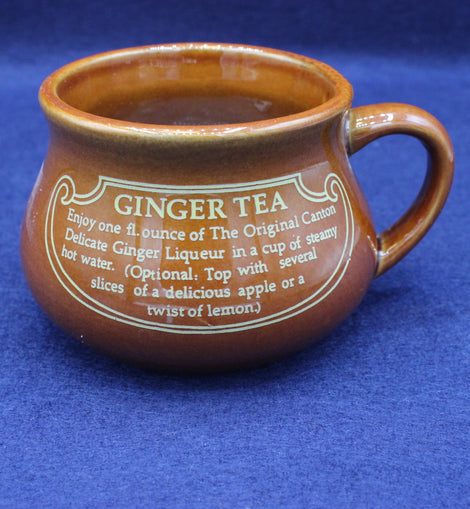 Brown ceramic mug with ginger tea instructions on a blue background