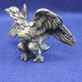 Brass eagle figurine on a blue background
