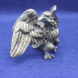 Brass eagle figurine on a blue background