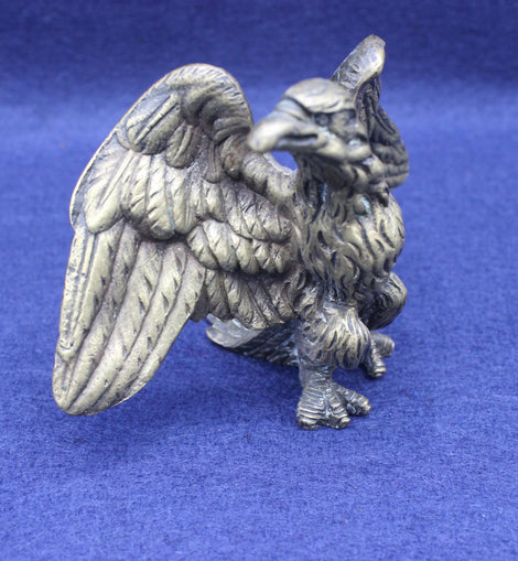 Brass eagle figurine on a blue background