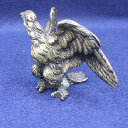 Brass eagle figurine on a blue background