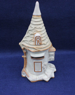 Decorative ceramic mailbox with a pointed roof on a blue background