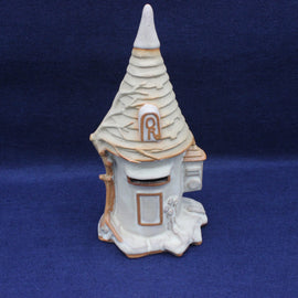 Decorative ceramic mailbox with a pointed roof on a blue background