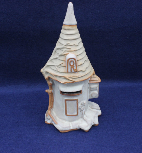 Decorative ceramic mailbox with a pointed roof on a blue background