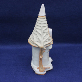 Ceramic sculpture of a stylized tree on a blue background