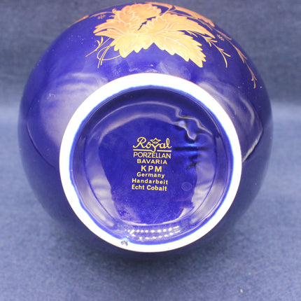 Blue glass vase with gold floral design on a blue background