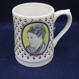 White mug with decorative border and portrait on a blue background