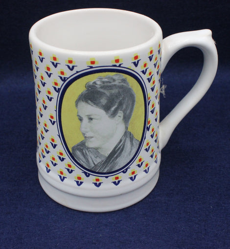 White mug with decorative border and portrait on a blue background