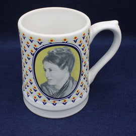 White mug with a portrait of a grace darling and decorative border on a dark blue background