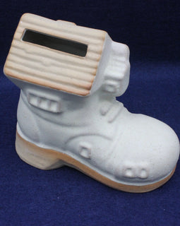 White ceramic boot money box on a blue background