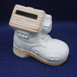 White ceramic boot money box on a blue background