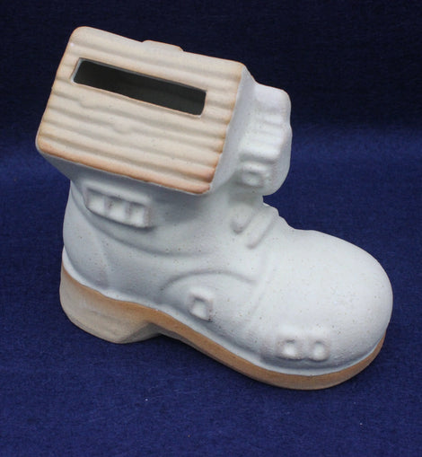 White ceramic boot money box on a blue background