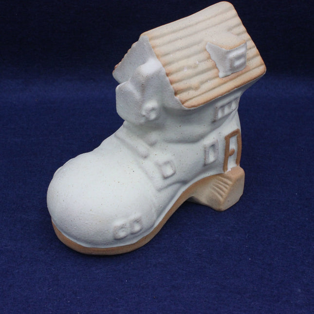 White ceramic shelf pottery boot house against a blue background