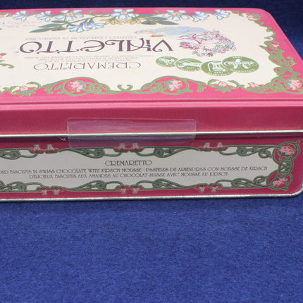 Decorative pink tin box with floral design on a blue background