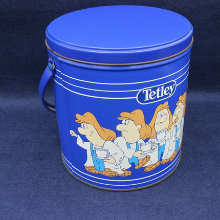 Blue tin can with cartoon characters and Tetley logo on a dark blue background