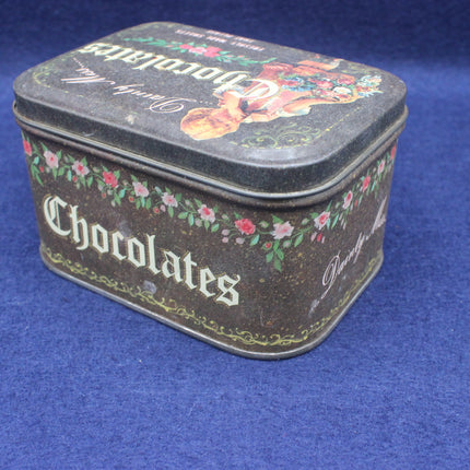 Decorative chocolate tin with floral designs on a blue background