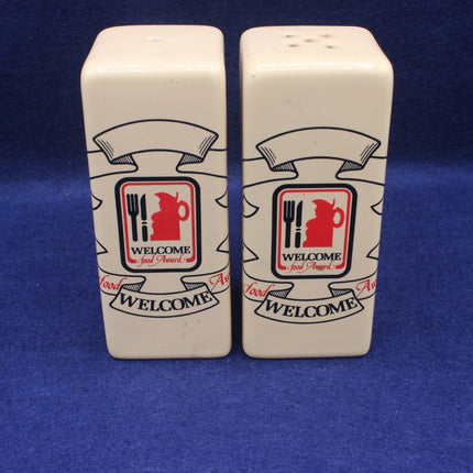 Two salt and pepper shakers with a 'Welcome' logo on a blue background
