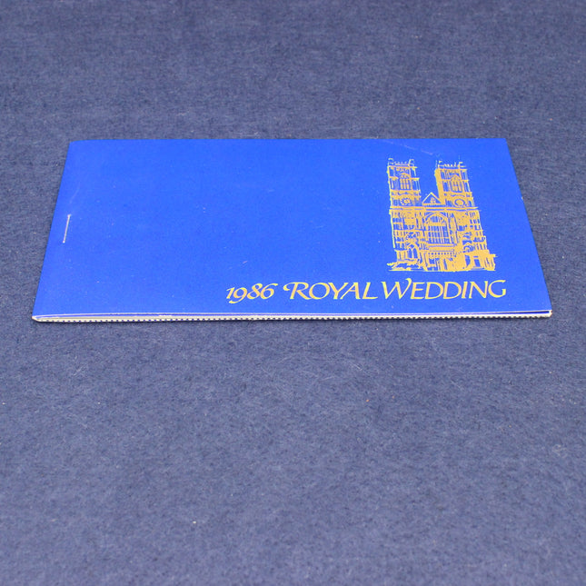 Blue book with '1986 Royal Wedding' text and a castle illustration on a blue background