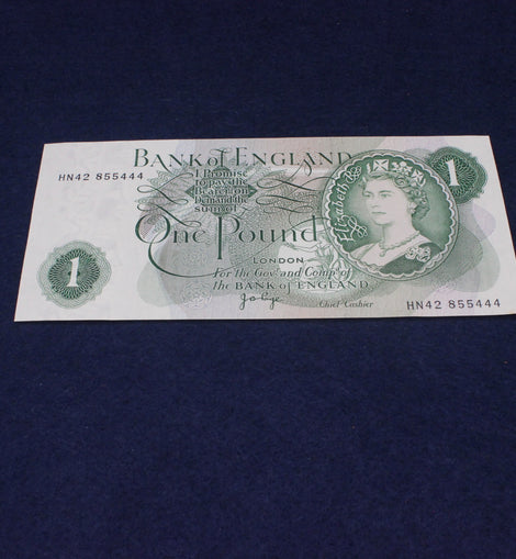 One pound banknote from the Bank of England on a dark blue background