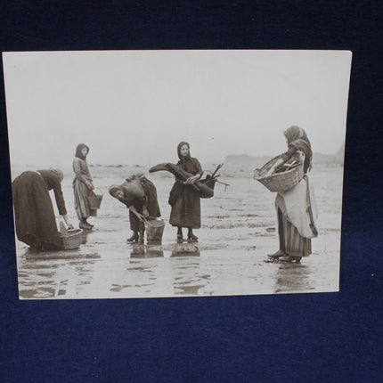 Vintage black and white photo of women by a body of water with baskets.