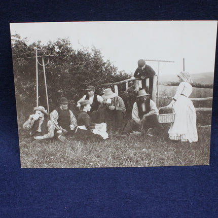 Vintage black and white photo of a group of people outdoors, possibly at a picnic.