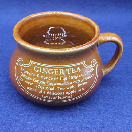 Brown ceramic mug with ginger tea text on a blue background