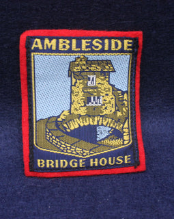 Embroidered patch of Ambleside Bridge House on a dark blue fabric background