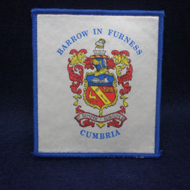 Embroidered patch with coat of arms and text on a white background