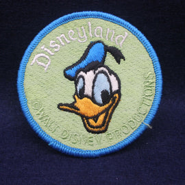 Embroidered patch with Donald Duck's face and 'Disneyland' text on a dark background