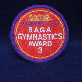 Embroidered patch with 'B.A.G.A. Gymnastics Award 3' on a red background with purple border.