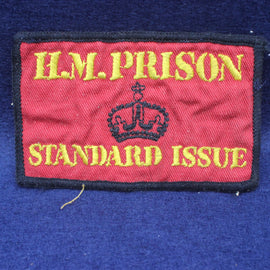 Red patch with 'H.M. Prison Standard Issue' text and a crown emblem on a blue background